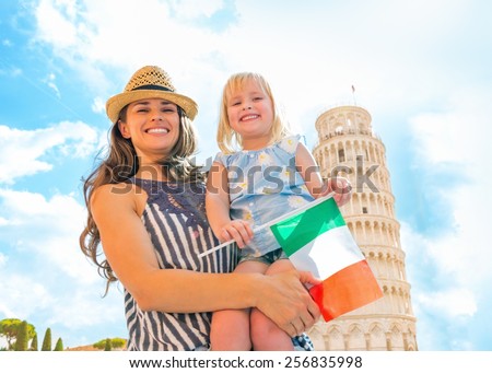 Portrait of smiling mother and baby girl with italian flag in front of leaning tower of pisa, tuscany, italy