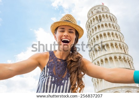Portrait of young woman making selfie in front of leaning tower of pisa, tuscany, italy