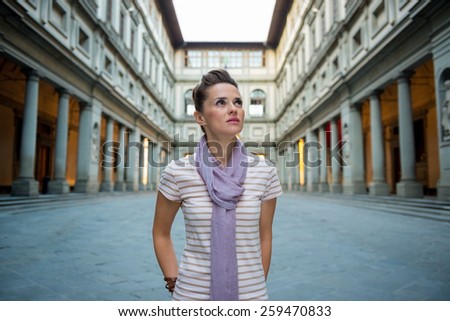 Portrait of young woman near uffizi gallery in florence, italy looking into distance