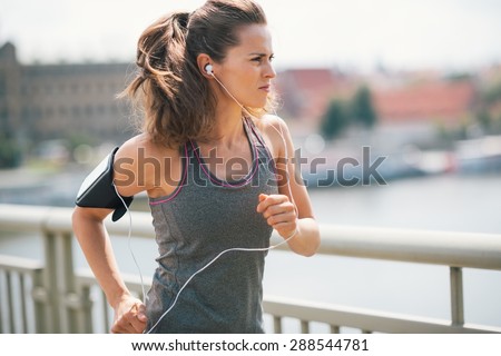 Rock on, run on, power through. That is the stuff of champions. A brunette, long-haired jogger is deep in thought, focused on her goal and being motivated by her the music she is listening to.