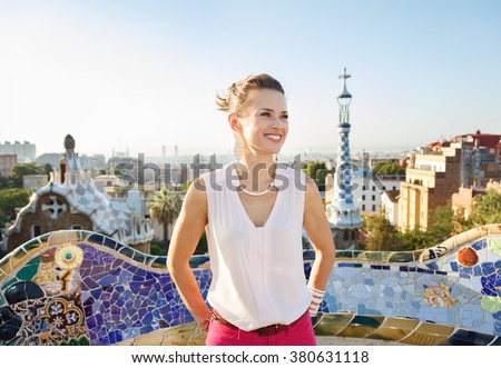 Refreshing promenade in unique Park Guell style in Barcelona, Spain. Happy young woman tourist in Park Guell, Barcelona, Spain looking into the distance