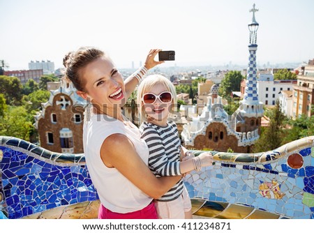 Barcelona will show you how to remarkably spend holiday. Smiling mother and baby taking photos with digital camera at Park Guell