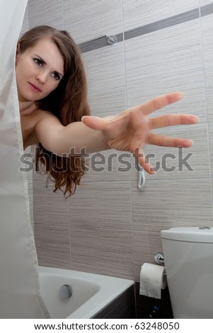 woman behind curtain streching for something at bathroom