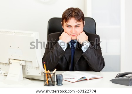 Business man sitting at office desk and keep head on hands