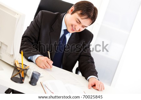 Successful business man signing important  contract in office
