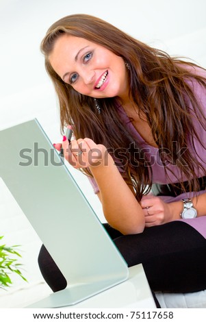 Smiling attractive woman sitting in front of mirror and applying lipstick
