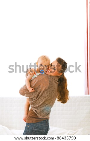 Young mom showing her baby something by pointing in camera