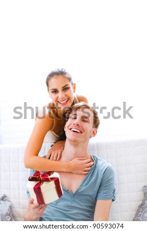 Young woman present gift to her husband