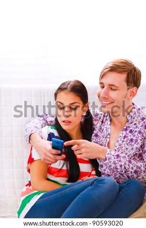 Young man showing something in mobile to her surprised girlfriend