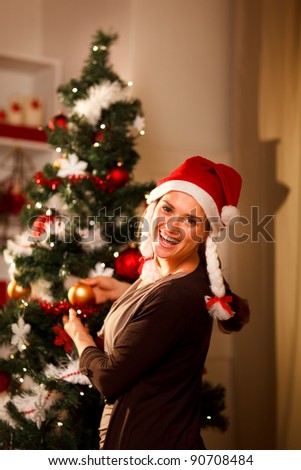 Happy girl decorating Christmas tree