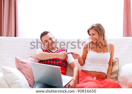 Concerned husband giving credit card to his pregnant wife
