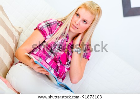 Portrait of dreaming young woman with magazine