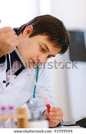 Researcher working with test tube at cabinet