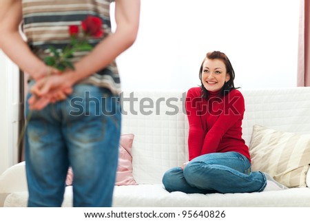 Guy hiding red rose to make surprise to girlfriend