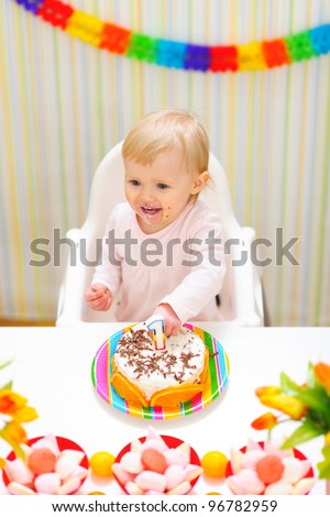 Happy eat smeared baby eating first birthday cake