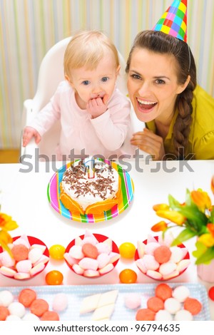 Portrait of happy mom and baby with birthday cake