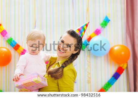 Portrait of happy mom and baby with birthday gift