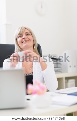 Middle age business woman having cup of coffee and dreaming