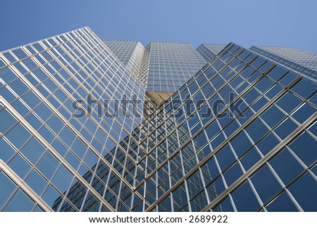 looking up at blue skyscraper from base