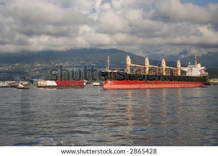 Empty ship and tug pulling barge with container