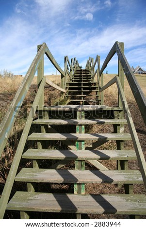 wooden staircase with railings leading upwards