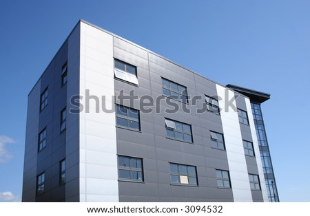 small modern office building against blue sky