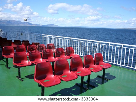 red plastic chairs on deck of ship