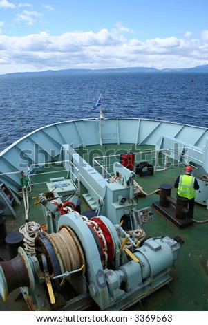 bow of ship with machinery and crew member