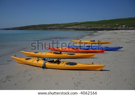 colourful kayaks on beach by turquoise waters