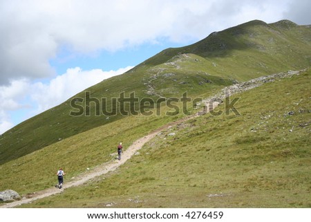 couple walking up path to Scottish mountain
