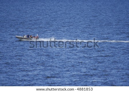 speed boat with wake in blue sea