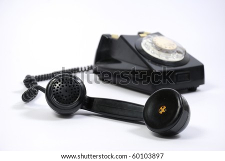 Old black phone with focus on the handset in the foreground