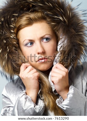 Young women in fur hood with worried expression on face.