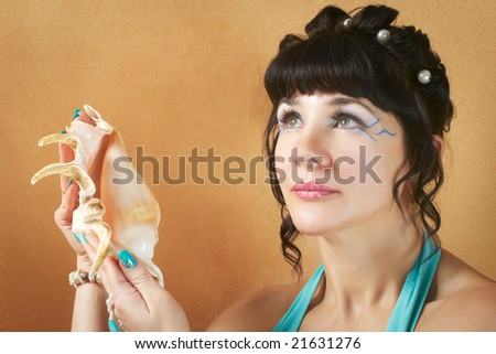 girl with bright make-up and shell at hand