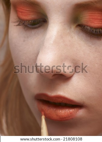 Close up of applying orange lipstick