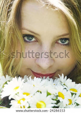 portrait of beautiful smiling girl with daisies