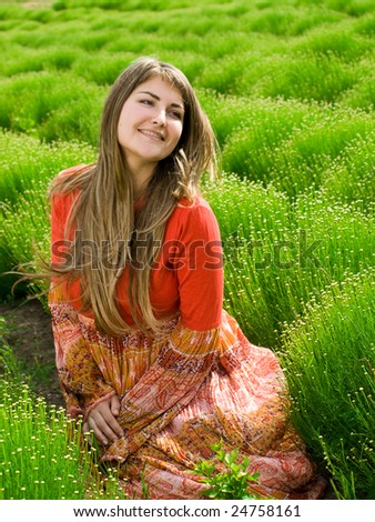 beautiful young woman in green field looking left