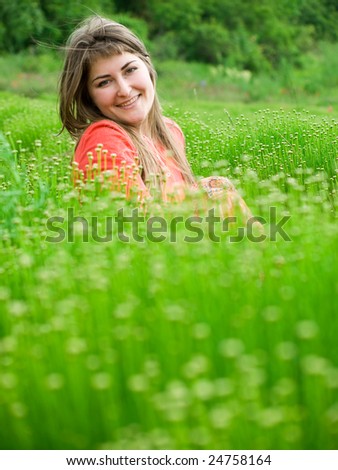 beautiful young woman in green field looking left