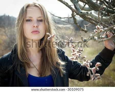 fashion model holding tree branch with buds