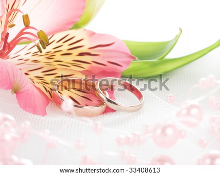 stock photo Closeup of wedding rings on white veil with flowers