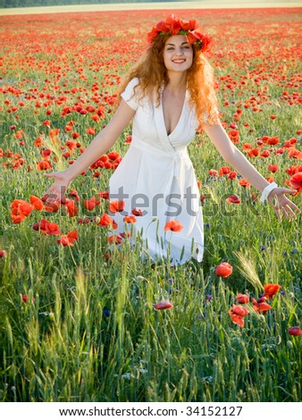 Young girl redheaded girl in poppies field