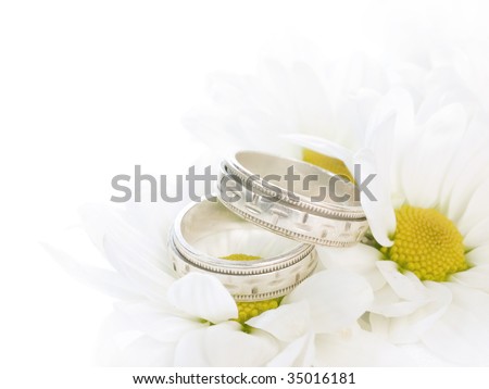 stock photo Closeup of wedding rings on flowers isolated on white