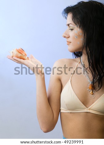 beautiful summer girl with shell on blue background