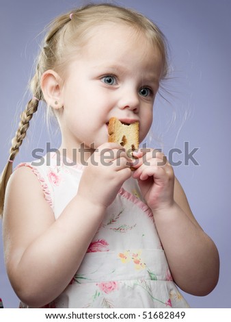 adorable little girl eating cookie