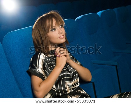 young fashion girl watching film in cinema