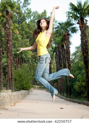 beautiful girl relaxing jumping outdoors in park