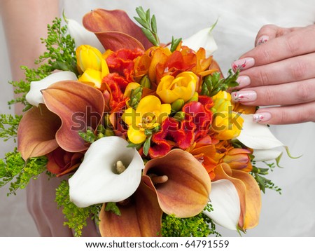 close-up of colorful wedding bouquet at bride\'s hands