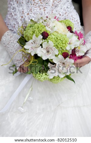 wedding bouquet of white and green flowers at girl\'s hand