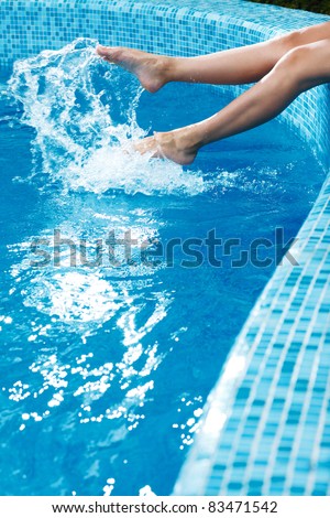 girl\'s beauty legs in the pool making splashes