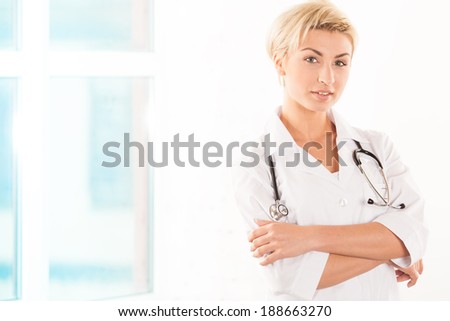 Portrait of doctor standing arms crossed in hospital room
